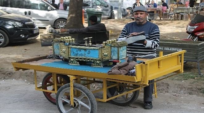 El arabasında boyacılık yapıyor